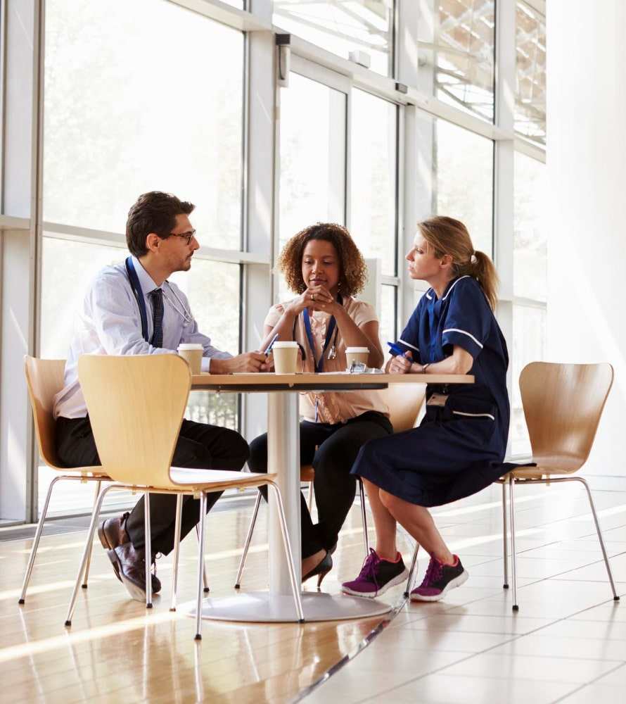 Illustration of three colleagues talking in a clinic corridor. Not Villa employees.