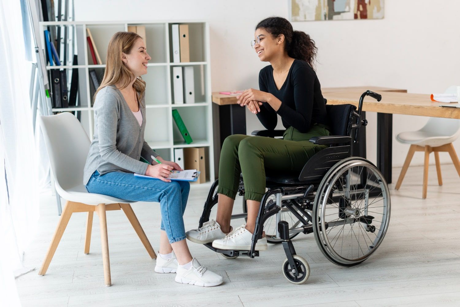 Illustration of two people talking in a community-centre foyer, one using a cane. Not a Villa participant or employee.